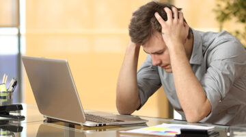 Worried businessman lamenting in front of a computer