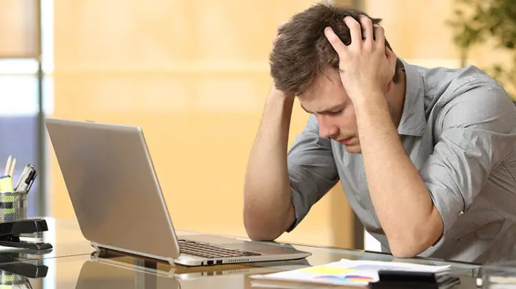 Worried businessman lamenting in front of a computer