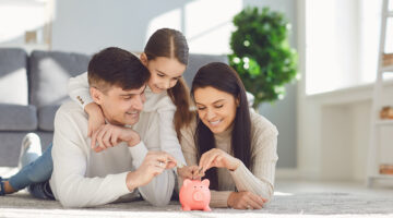 Happy family saves money in a piggy bank