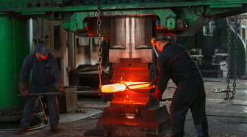 two men holding two grey metal tools