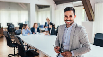 Successful entrepreneur, colleagues working in the background.