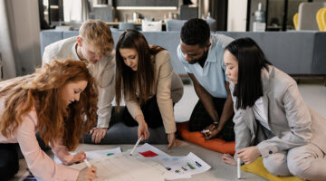 A team writing on a piece of paper on the floor