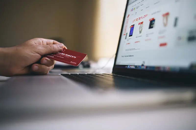 Person using payment card in front of computer