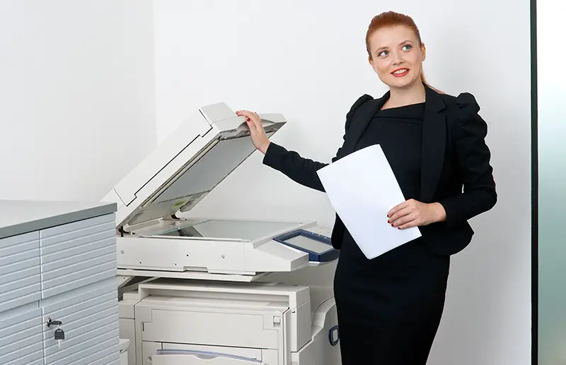Woman holding a document near scanning machine