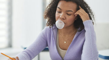 Woman blowing her bubble gum while taking her exam