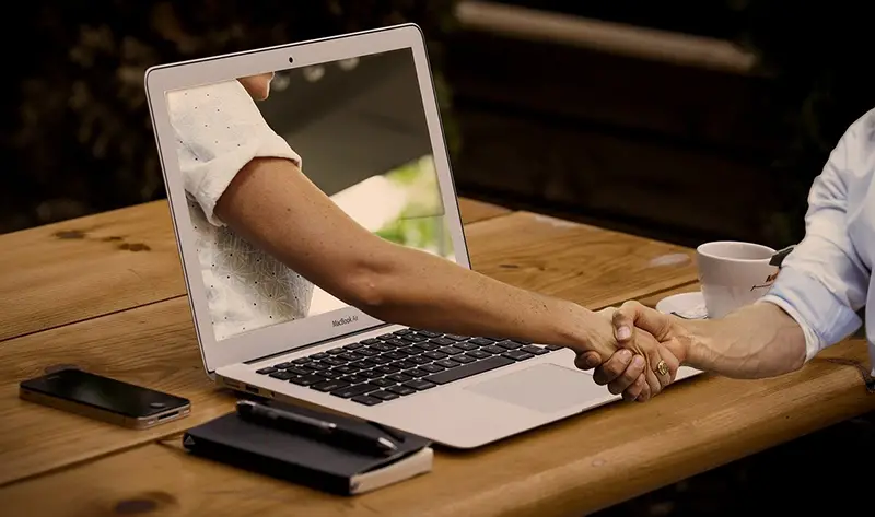 Handshake near laptop