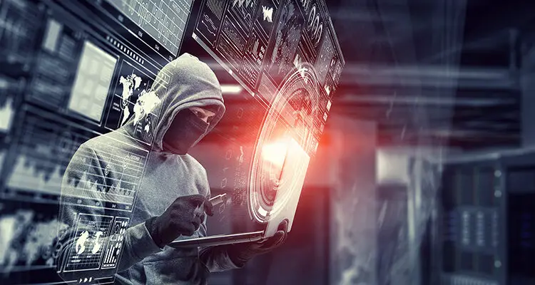 Computer hacker in hoodie and mask stealing data from laptop