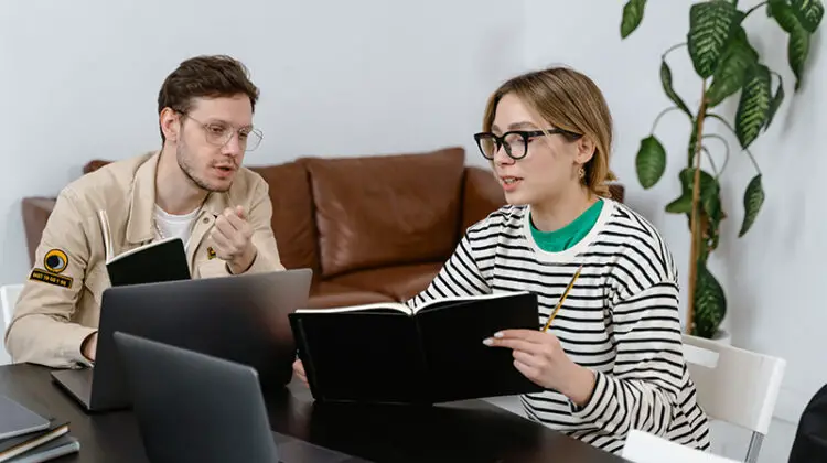 man and woman discussing in workplace