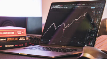 Black and silver laptop with trading graph on the screen