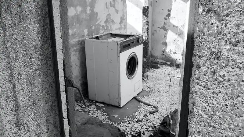 Old white destroyed washing machine