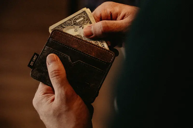 Person holding brown wallet