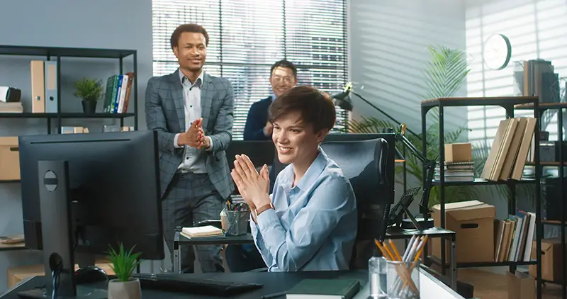 Mixed-race co-workers clapping hands behind
