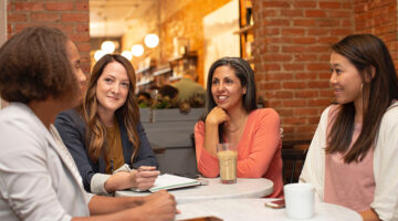 Four women talking inside the cafeteria