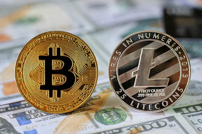 Bitcoin and Litecoin on Us Dollars banknotes background with credit cards