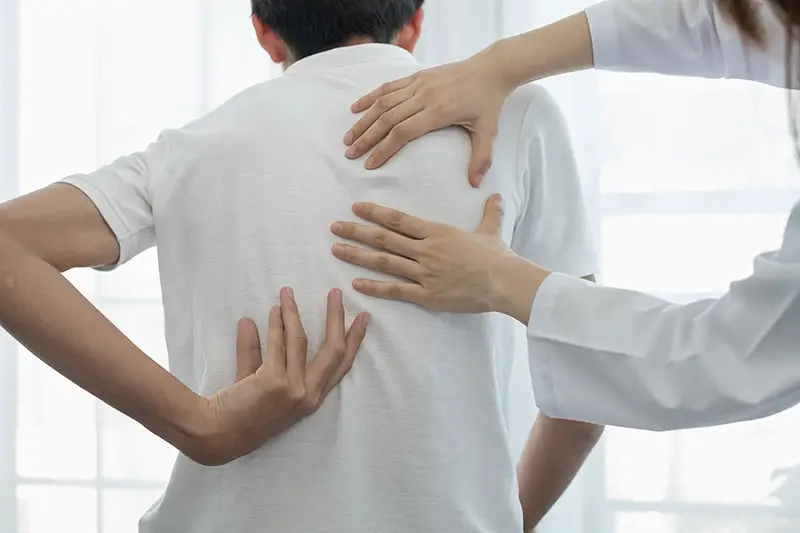 Female physiotherapists provide physical assistance to male patients with back injuries