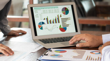 Financial analyst analysis business financial report on digital tablet during discussion at meeting