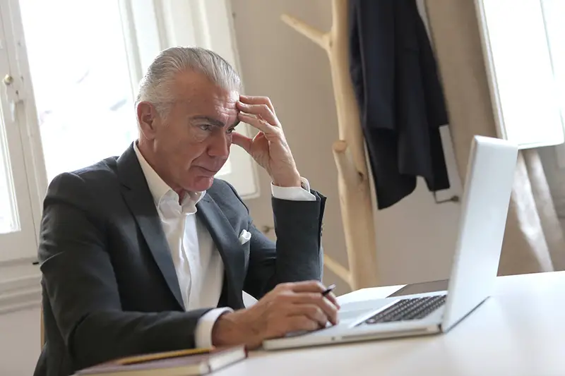 Man in black suit using laptop