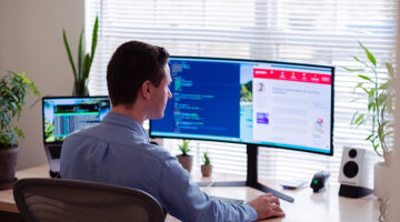 Man in gray sitting on chair in front of computer