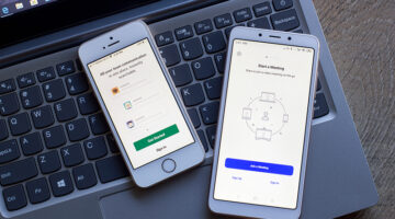 Two mobile phones on the top of laptop keyboard
