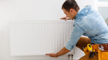 man fixing a heating radiator