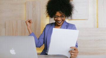 woman wearing purple blazer holding a paper