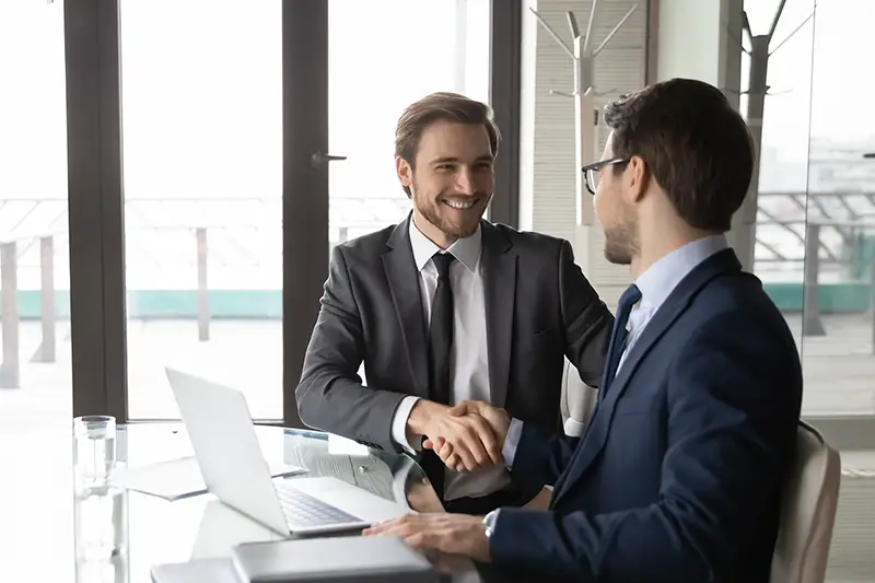 Smiling businessman shaking client hand