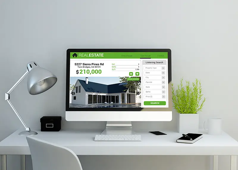 Modern clean workspace mockup with real estate website on screen