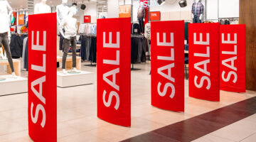 Large red panels with a sale sign at the entrance to a clothing store.