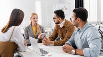 businesswoman with digital tablet having a conversation with her multiethnic colleagues