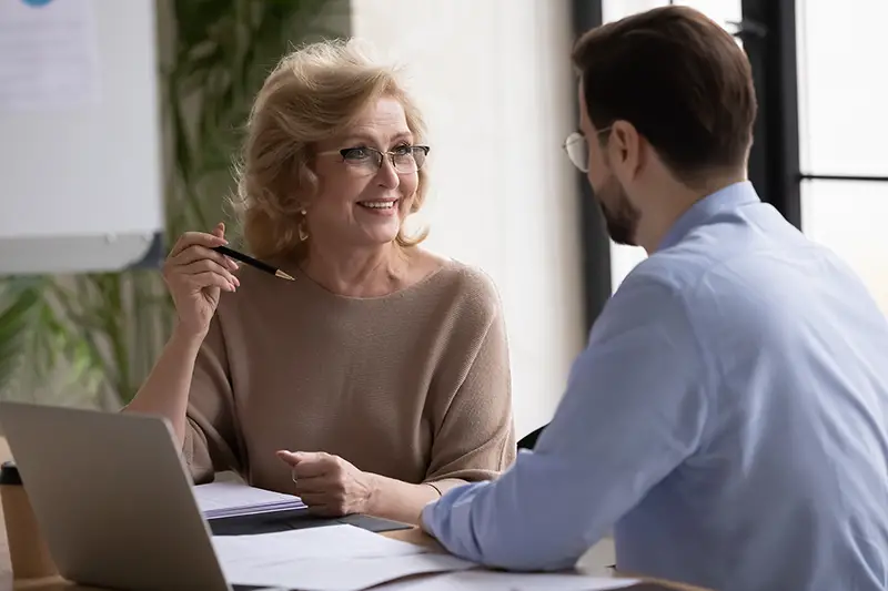 Woman financial coach talking to a young male client