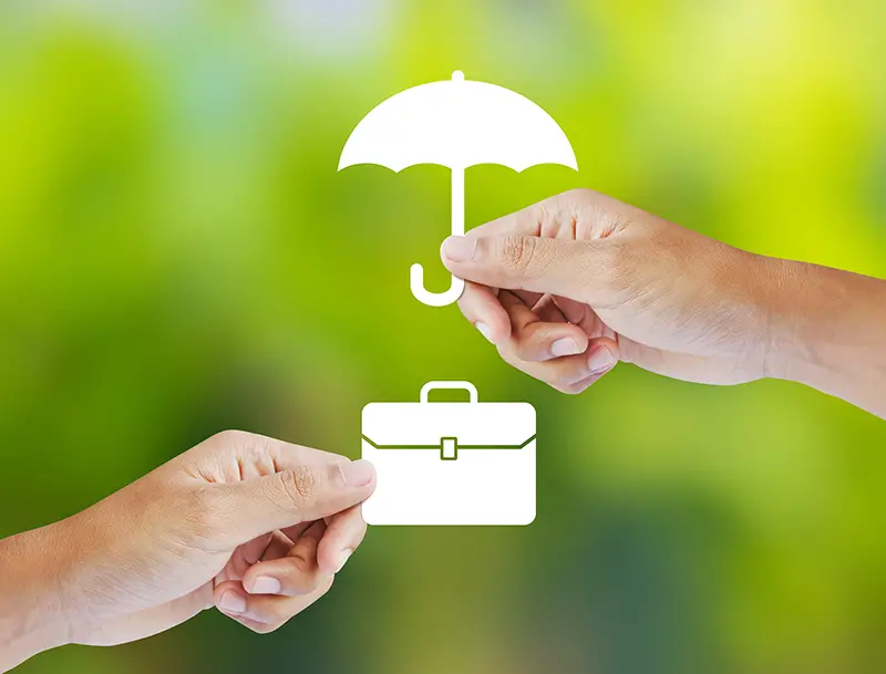 Business insurance concept with an umbrella covering business briefcase