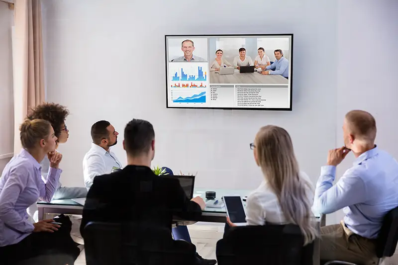 Group Of Skillful Businesspeople Video Conferencing In Boardroom