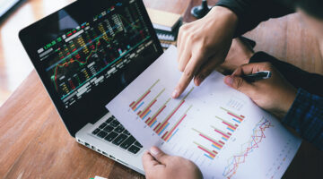 Business man hand holding pen and pointing graph chart