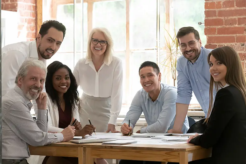 Professional business team young and old people posing together at office table