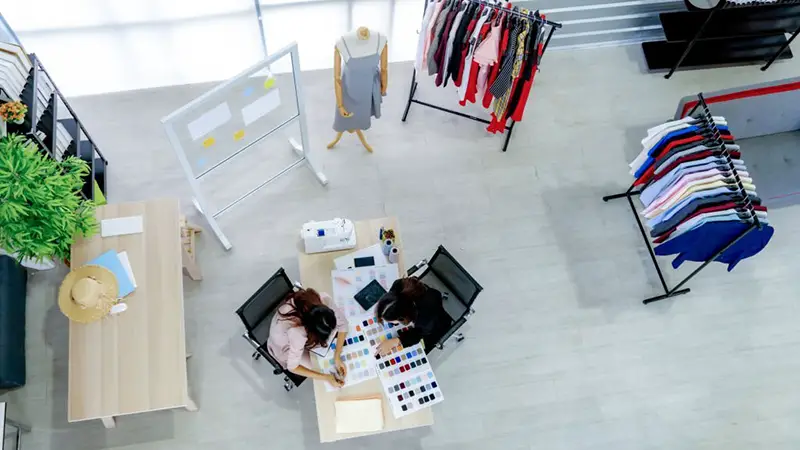 Top view of two young designer in clothing store