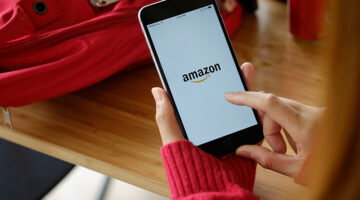 Woman holding iPhone 7 Plus showing Amazon apps