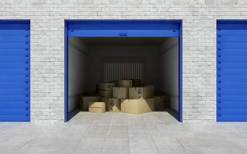Open self storage unit full of cardboard boxes
