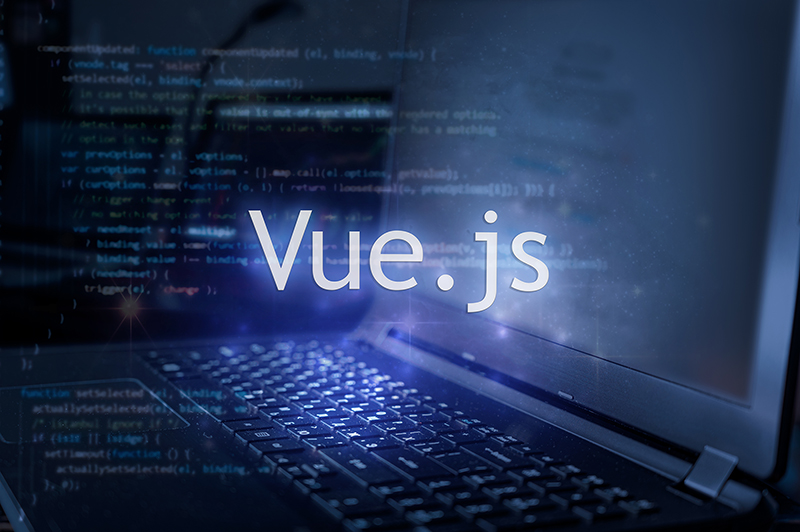 Vue.js inscription against laptop and code background