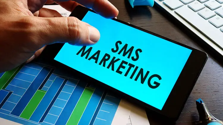 Man holding smartphone with words sms marketing.