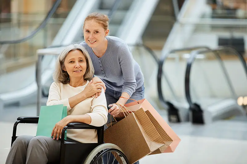 Daughter and a disabled mother with shopping bags