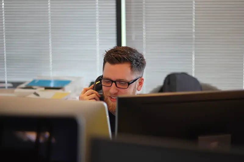 Man wearing eyeglass taking a phone call