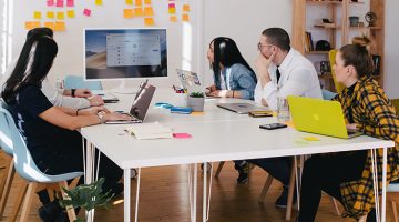 five person by table watching turned on white iMac