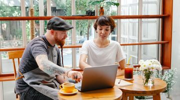 A couple sitting in front of their laptop