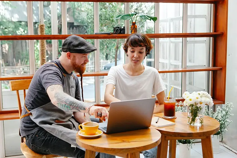 A couple sitting in front of their laptop