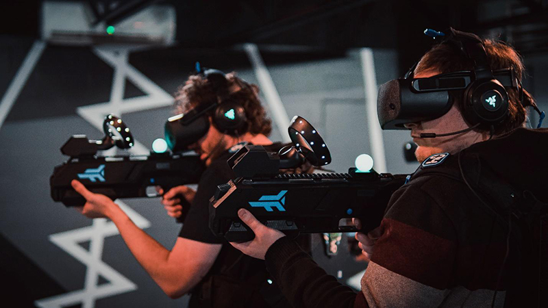 Men using virtual reality headset and weapon