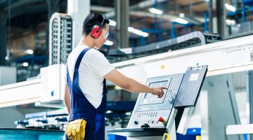 Worker entering data in CNC machine