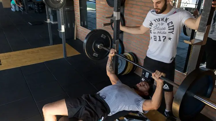 Young male personal trainer inside the gym