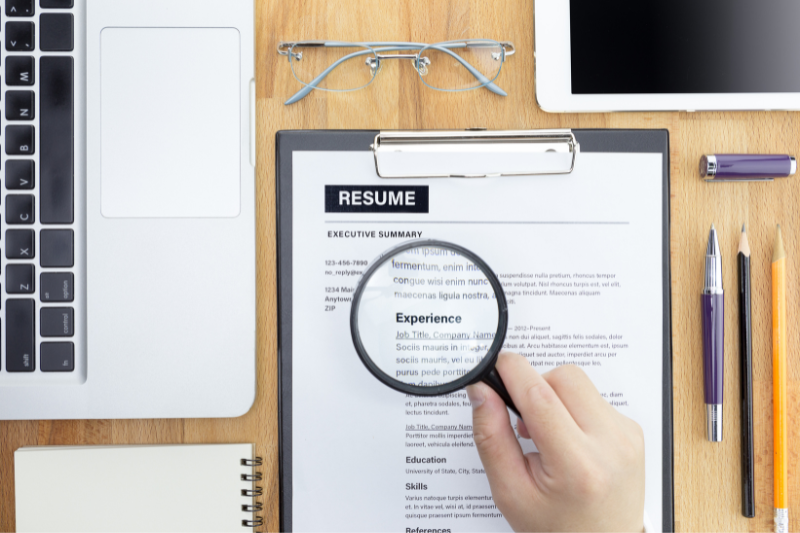 Magnifying glass on the top of a resume