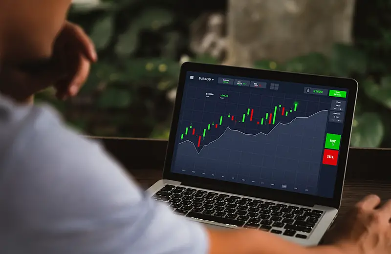 man sitting looking analyze stocks price on online marketplace on laptop computer
