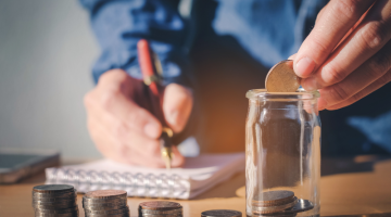 Person saving money on a glass jar